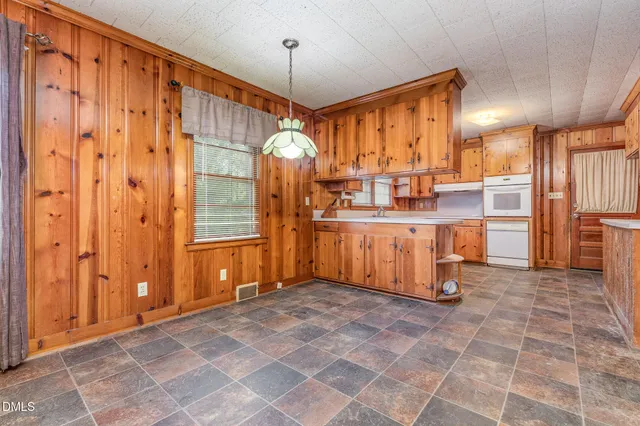 a view of kitchen with stainless steel appliances granite countertop cabinets and chandelier