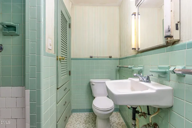 a bathroom with a sink toilet and a mirror