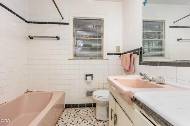 a bathroom with a sink a toilet a vanity and bathtub