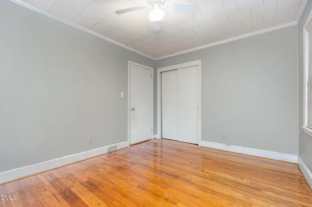 a view of empty room with wooden floor