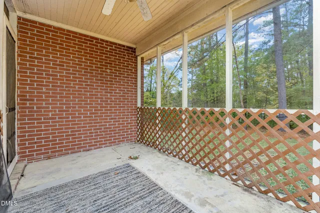 a view of a black gate with wooden floor and fence