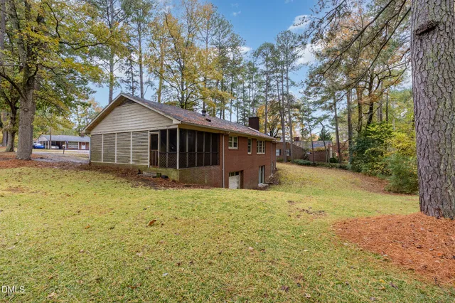 a yellow house sitting in middle of the middle of a yard