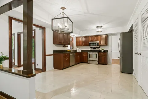 a kitchen with stainless steel appliances granite countertop a refrigerator a stove top oven a sink and dishwasher