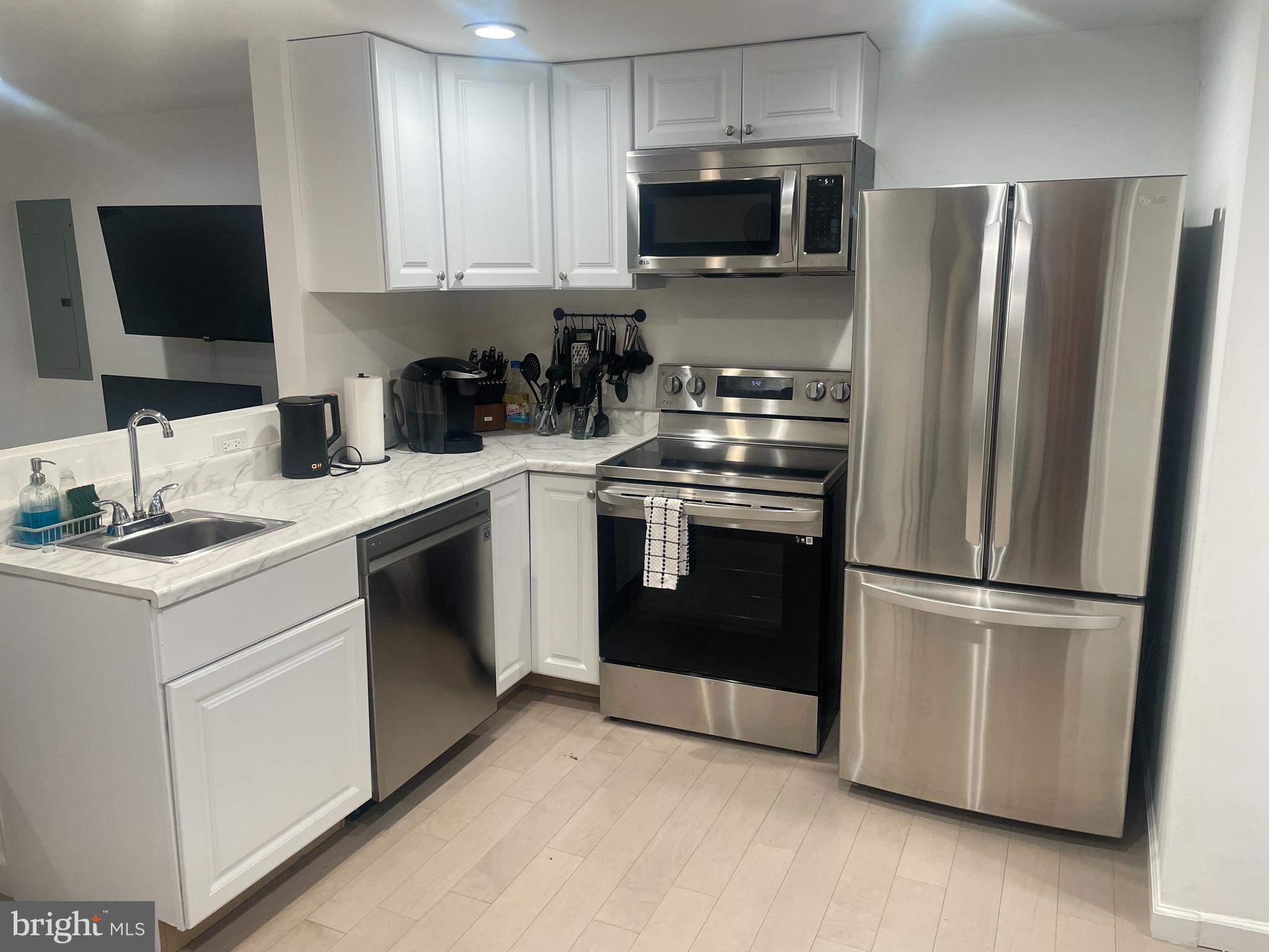 906 I Street Southeast, Unit 1 Washington, DC 20003 - Photo 4 of 19 a kitchen with stainless steel appliances granite countertop a refrigerator stove a sink and a microwave