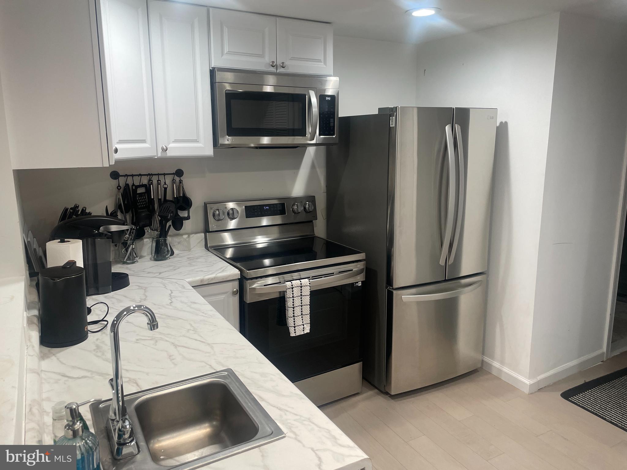 906 I Street Southeast, Unit 1 Washington, DC 20003 - Photo 5 of 19 a kitchen with stainless steel appliances a refrigerator a stove a microwave and cabinets