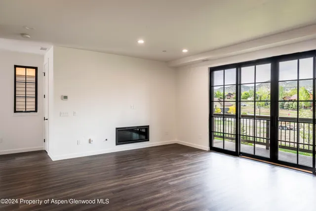 a view of empty room with wooden floor and fireplace