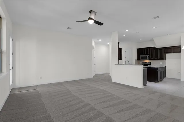 a view of a kitchen with kitchen island wooden floor center island and stainless steel appliances
