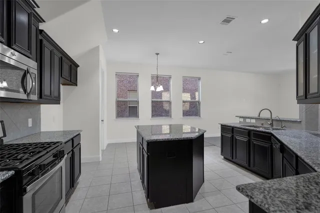 a kitchen with stainless steel appliances granite countertop a sink stove and cabinets