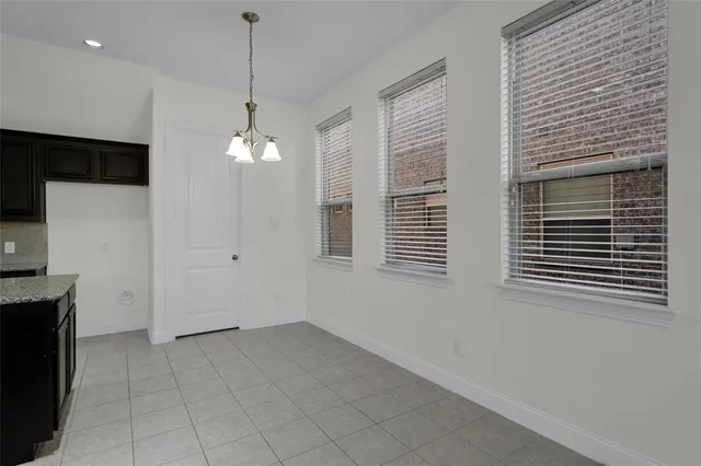 a view of a livingroom with a chandelier fan and windows