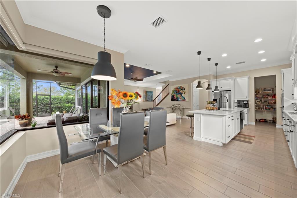 1608 Mockingbird Drive Naples, FL 34120 - Photo 11 of 29 a dining room with furniture a chandelier and wooden floor