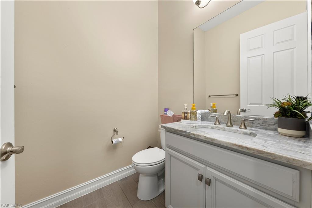 1608 Mockingbird Drive Naples, FL 34120 - Photo 17 of 29 a bathroom with a granite countertop sink a toilet and a mirror