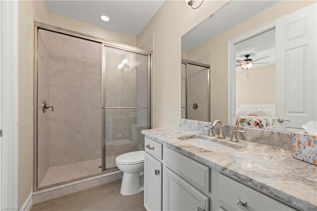 1608 Mockingbird Drive Naples, FL 34120 - Photo 22 of 29 a bathroom with a granite countertop sink toilet and shower