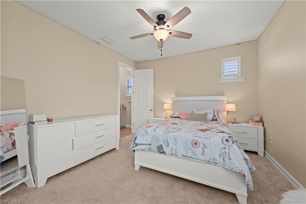 1608 Mockingbird Drive Naples, FL 34120 - Photo 24 of 29 a bedroom with a bed and a chandelier