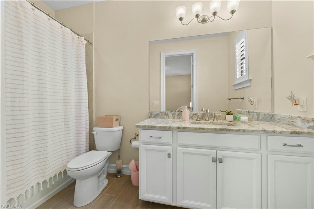 1608 Mockingbird Drive Naples, FL 34120 - Photo 25 of 29 a bathroom with a granite countertop toilet a sink and a mirror