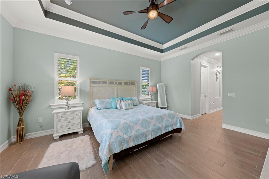 1608 Mockingbird Drive Naples, FL 34120 - Photo 6 of 29 a bedroom with a large bed and chandelier