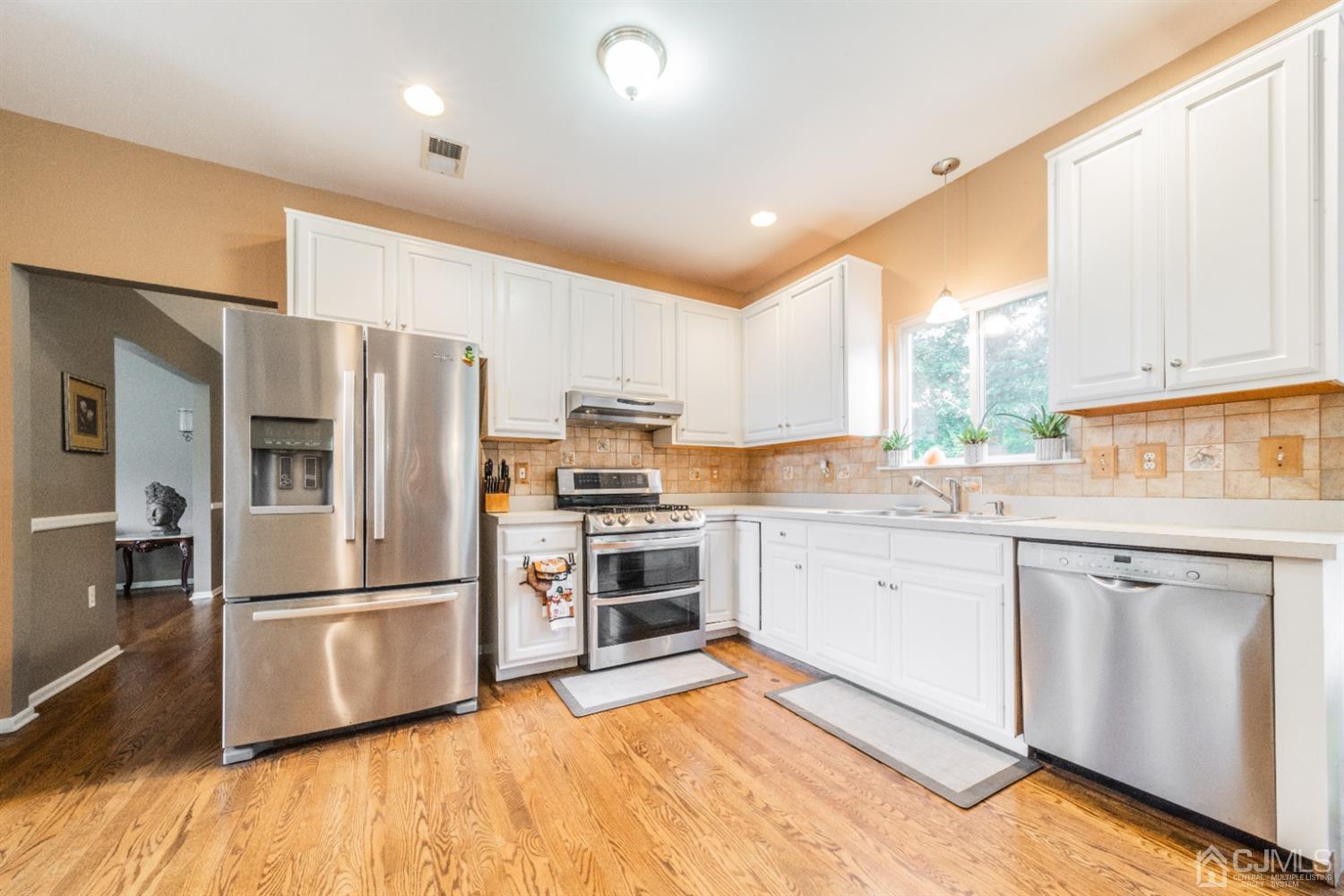138 Disbrow Road Matawan, NJ 07747 - Photo 8 of 32 a kitchen with granite countertop a refrigerator oven a sink dishwasher and white cabinets with wooden floor