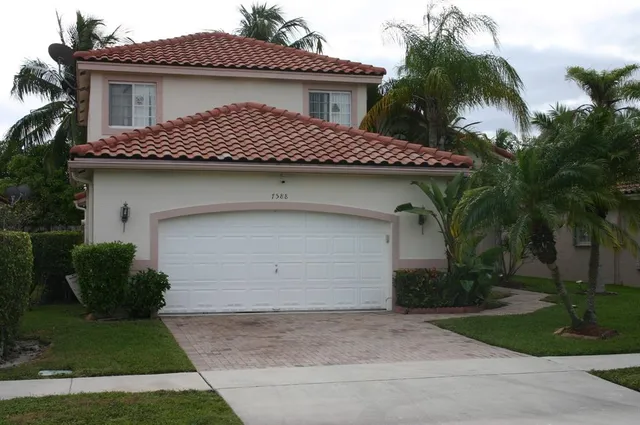 a front view of a house with a garden and plants