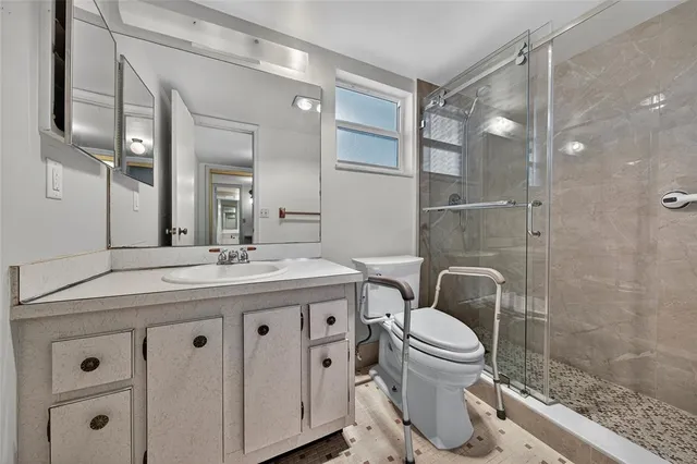 a bathroom with a granite countertop toilet a sink and a mirror