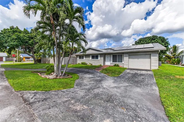 a view of a house with a yard and large tree