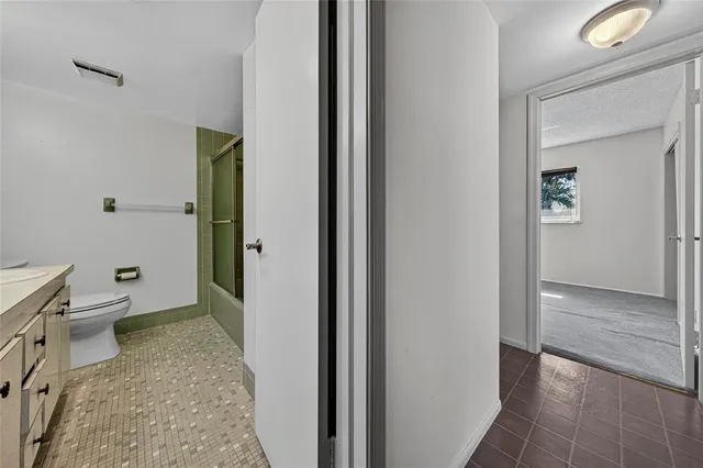 a bathroom with a granite countertop sink a toilet and shower