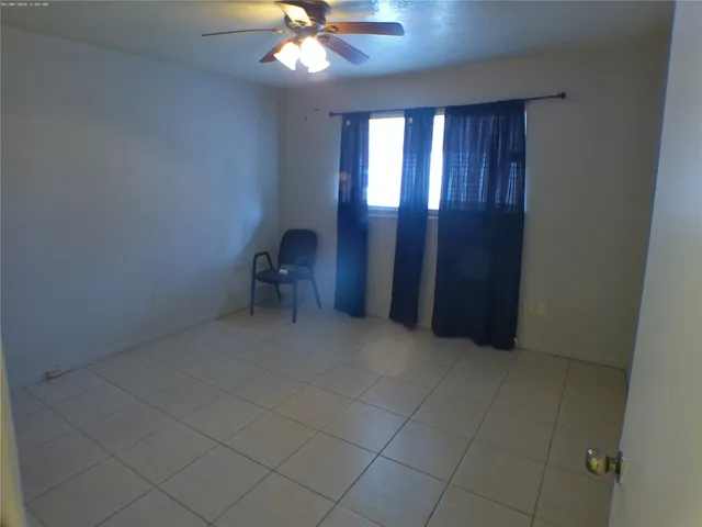 en empty room with windows and fan