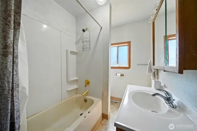 a bathroom with a tub sink and mirror