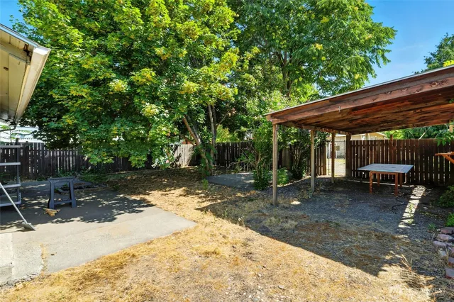 a backyard of a house with barbeque oven table and chairs
