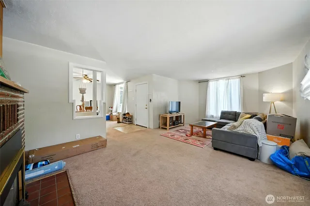 a living room with furniture a flat screen tv and a window