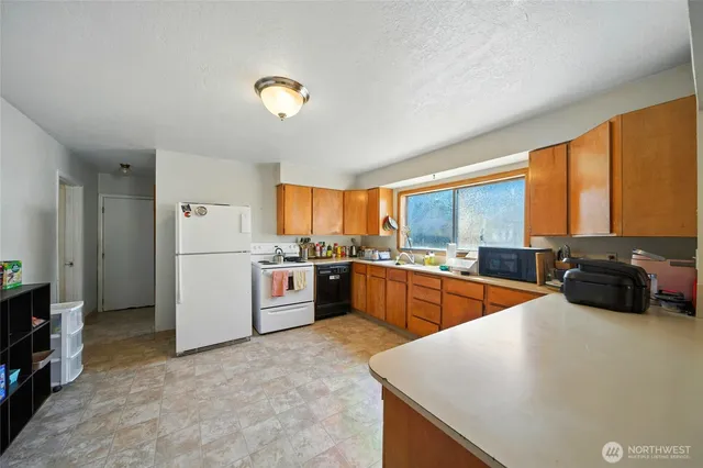 a large kitchen with a large window and stainless steel appliances