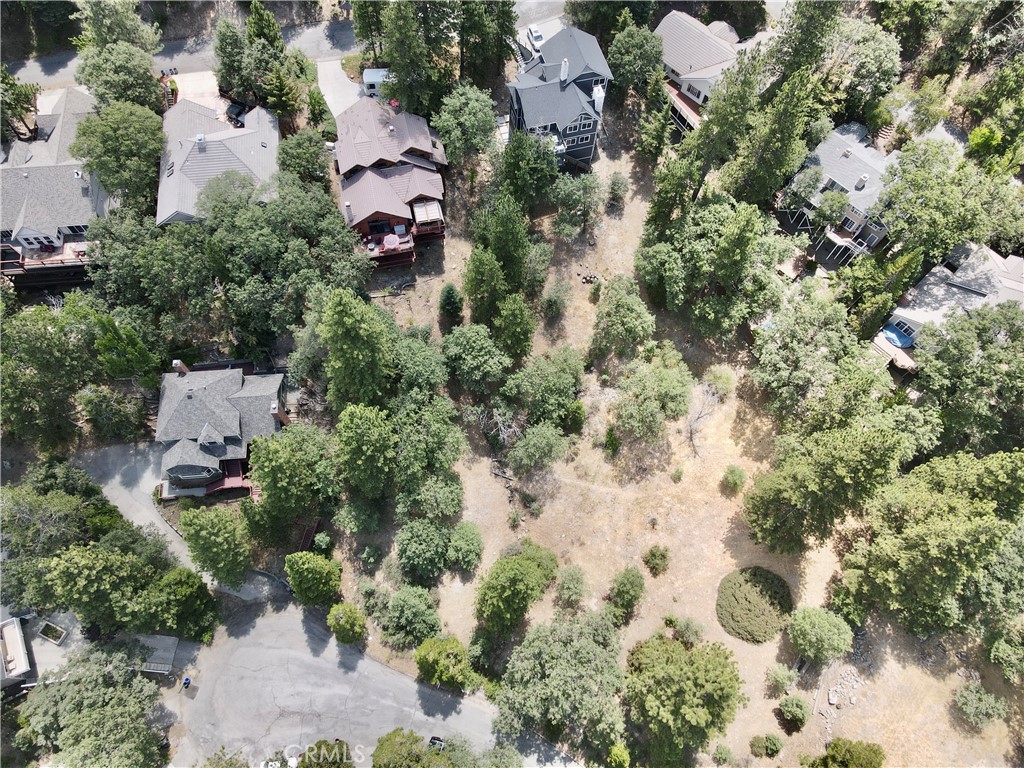 an aerial view of residential house with parking and trees