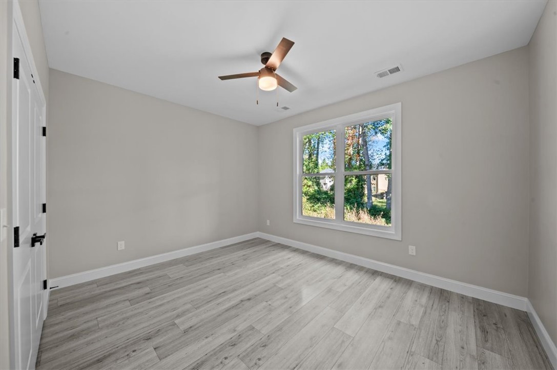 105 Bree Drive Anderson, SC 29621 - Photo 28 of 48 A well-lit bedroom features durable hardwood flooring and a functional ceiling fan for optimal comfort.