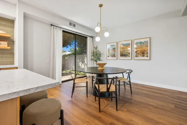 a view of a dining room with furniture a chandelier and wooden floor