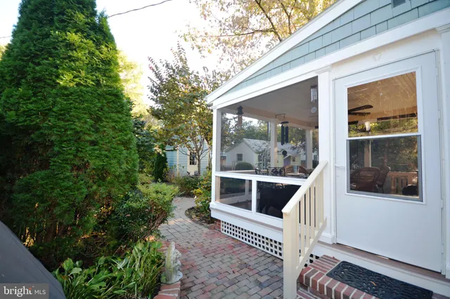 a view of a porch with chairs and floor to ceiling window and wooden fence