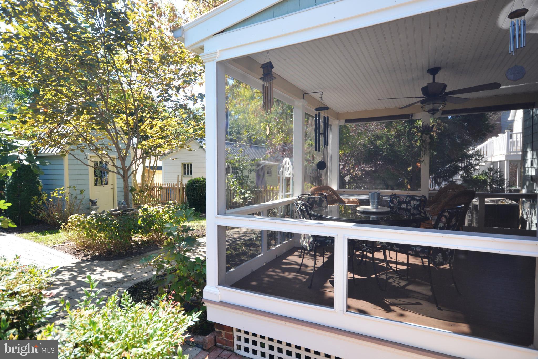 106 Grace Street St. Michaels, MD 21663 - Photo 14 of 57 a view of a porch with chairs and floor to ceiling window and wooden fence