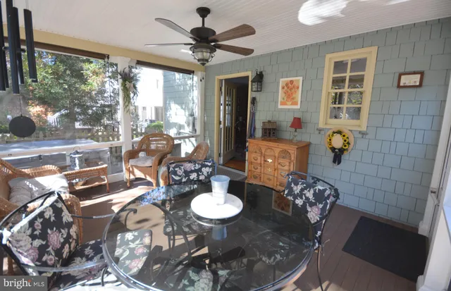 a view of a patio with table and chairs potted plants with floor to ceiling windows