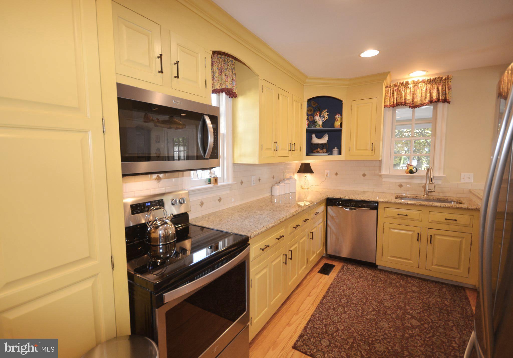 106 Grace Street St. Michaels, MD 21663 - Photo 32 of 57 a kitchen with granite countertop a sink stove and cabinets