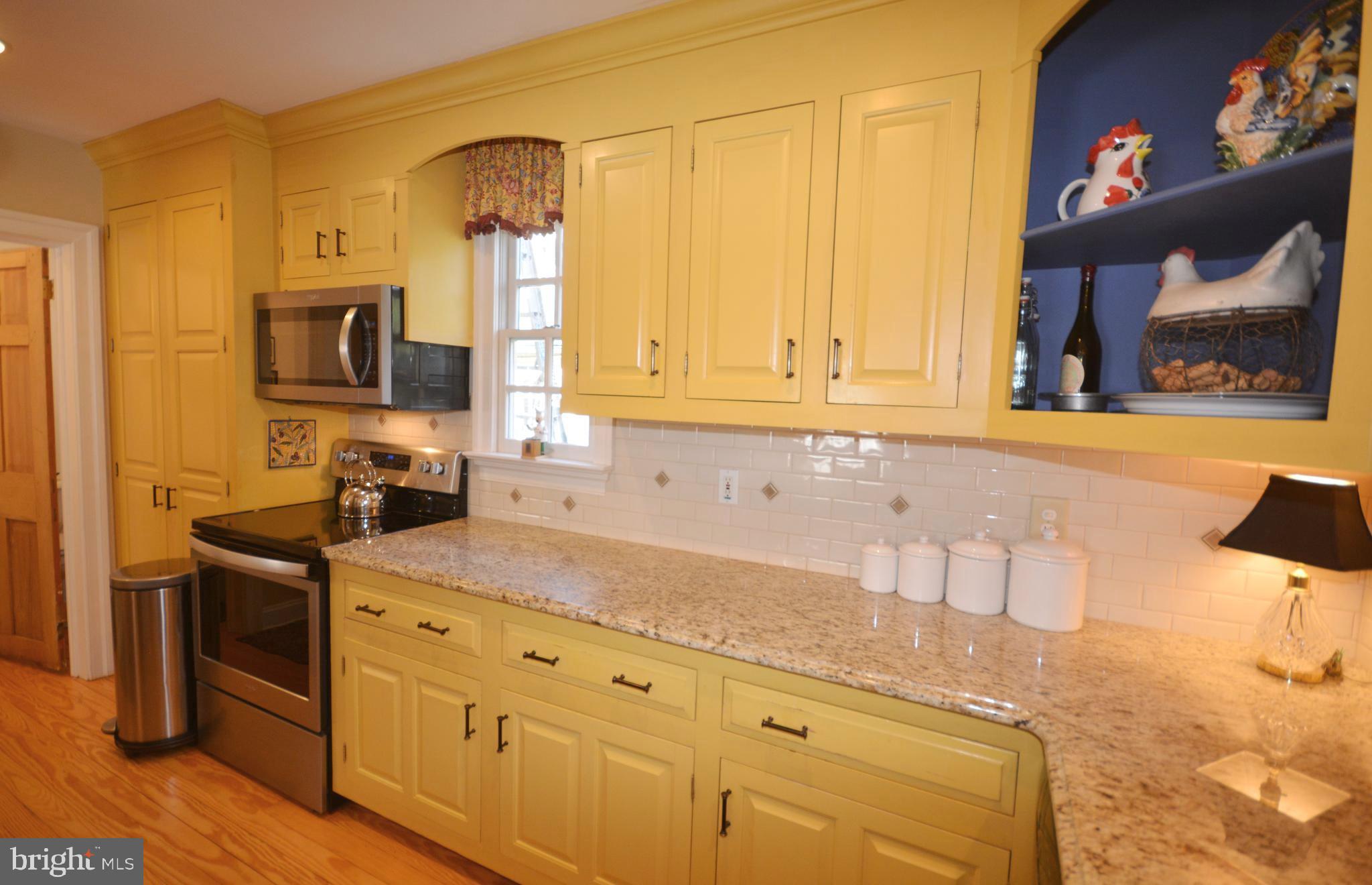 106 Grace Street St. Michaels, MD 21663 - Photo 34 of 57 a kitchen with stainless steel appliances granite countertop a sink a stove and a wooden cabinets