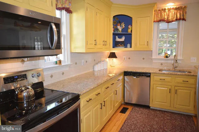 a view of staircase with lots of frames on wall and a window