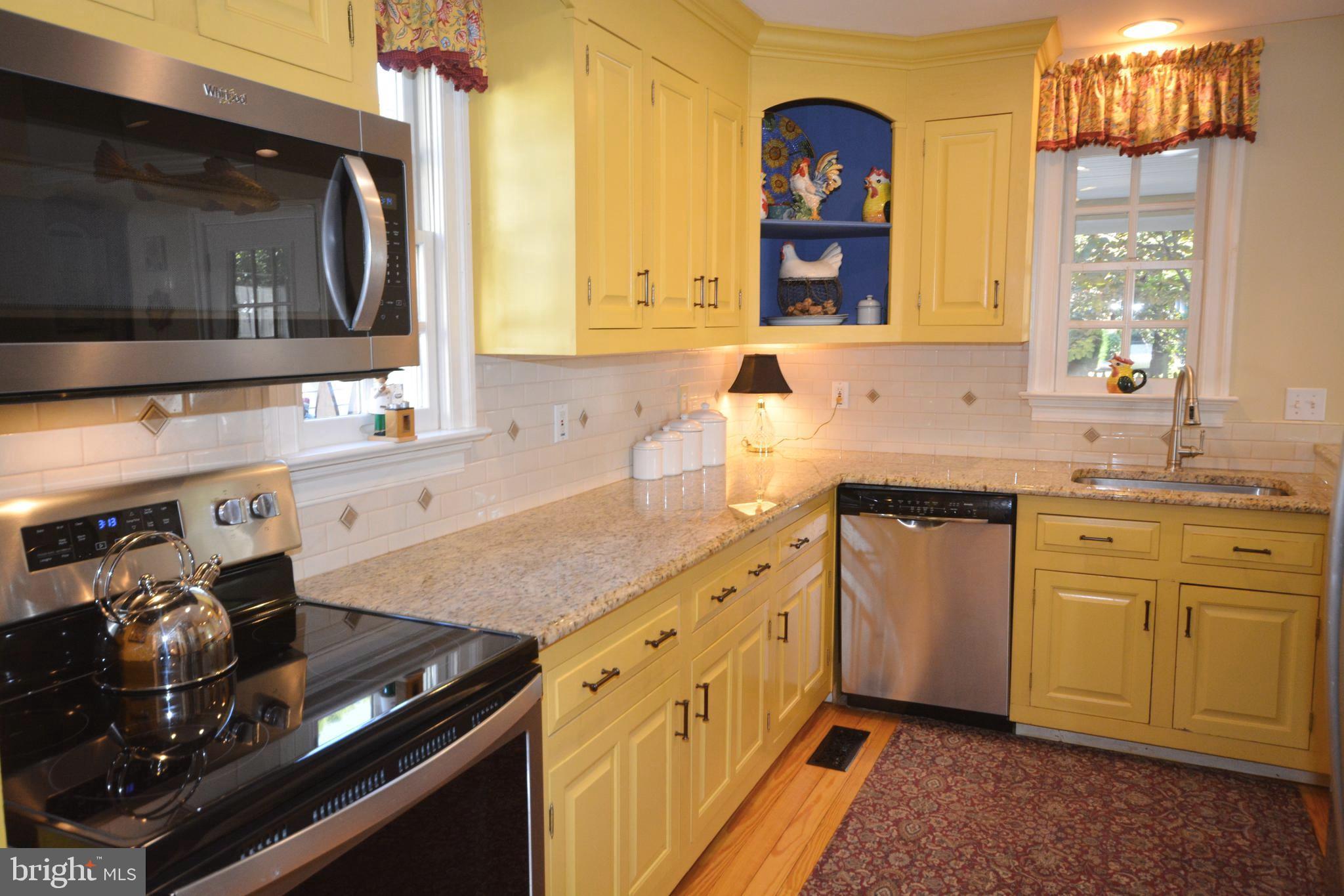106 Grace Street St. Michaels, MD 21663 - Photo 35 of 57 a kitchen with stainless steel appliances granite countertop a sink stove and cabinets