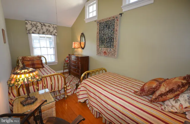 a bathroom with a granite countertop sink a mirror a toilet and shower