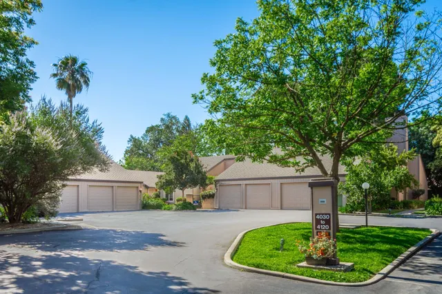 a front view of a house with a yard and trees