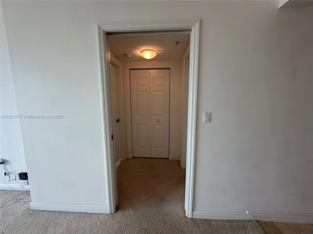 a view of an empty room with windows and closet