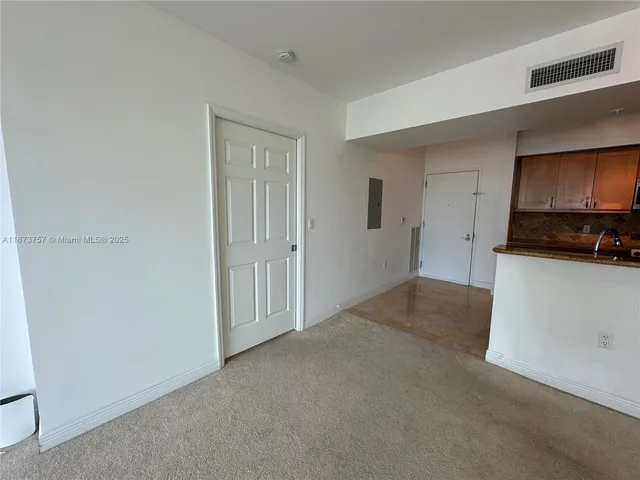 a view of a kitchen and an empty room with a kitchen