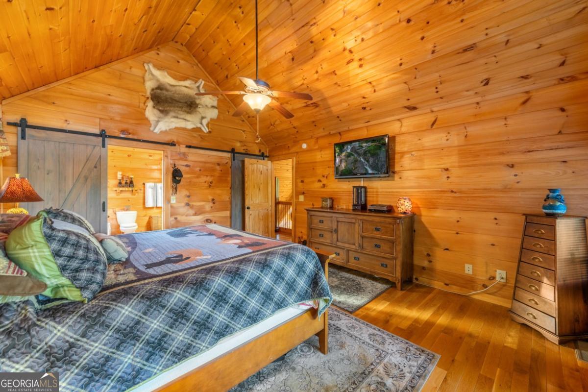 709 Laurel Creek Trail Blue Ridge, GA 30513 - Photo 24 of 87 a bedroom with a bed and a flat tv screen on dresser