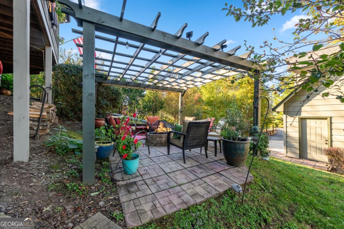 709 Laurel Creek Trail Blue Ridge, GA 30513 - Photo 47 of 87 a view of a patio with table and chairs potted plants and large tree