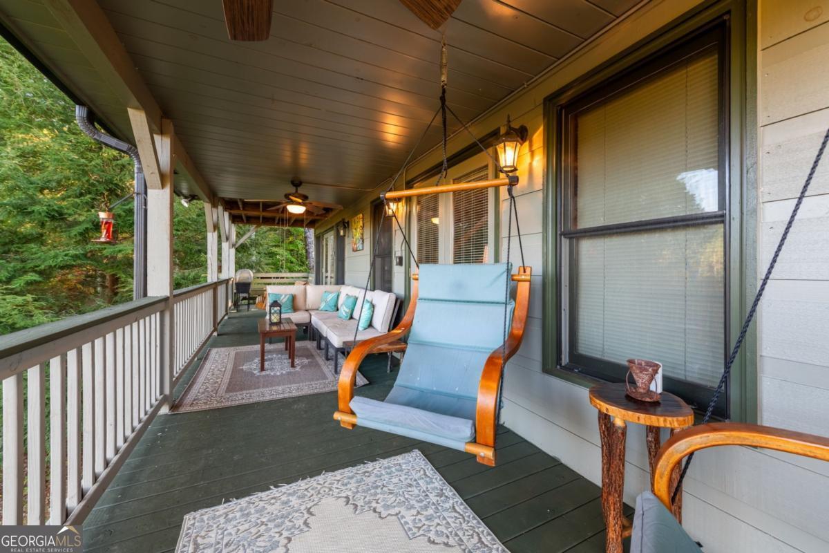 709 Laurel Creek Trail Blue Ridge, GA 30513 - Photo 61 of 87 a view of a patio with table and chairs with wooden floor and fence