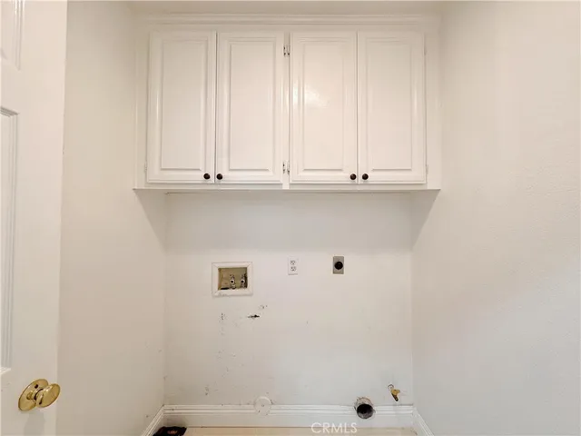 an empty room with wooden floor fireplace and windows