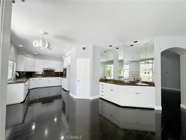 a kitchen with stainless steel appliances kitchen island granite countertop a refrigerator and a stove top oven