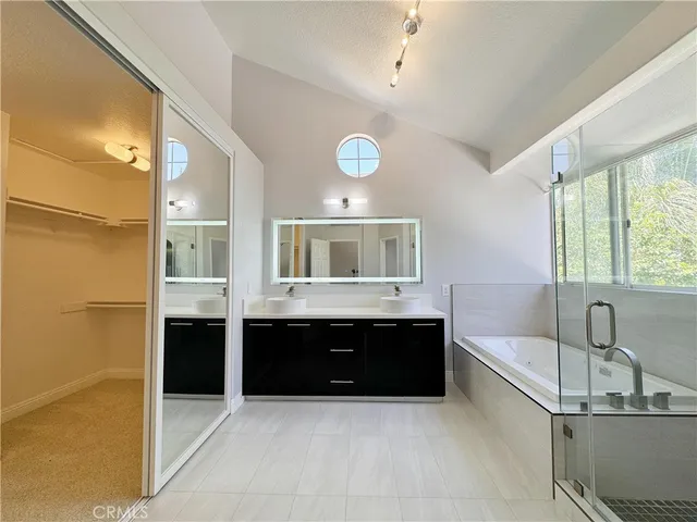a bathroom with a tub sink shower and mirror