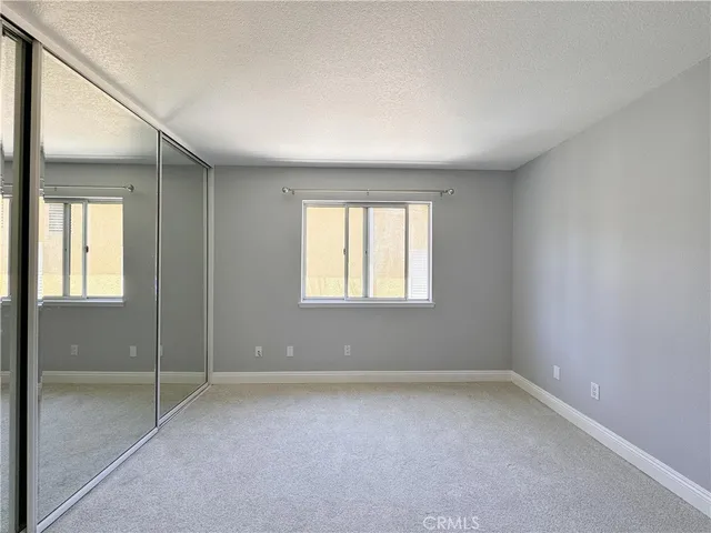 an empty room with windows and closet